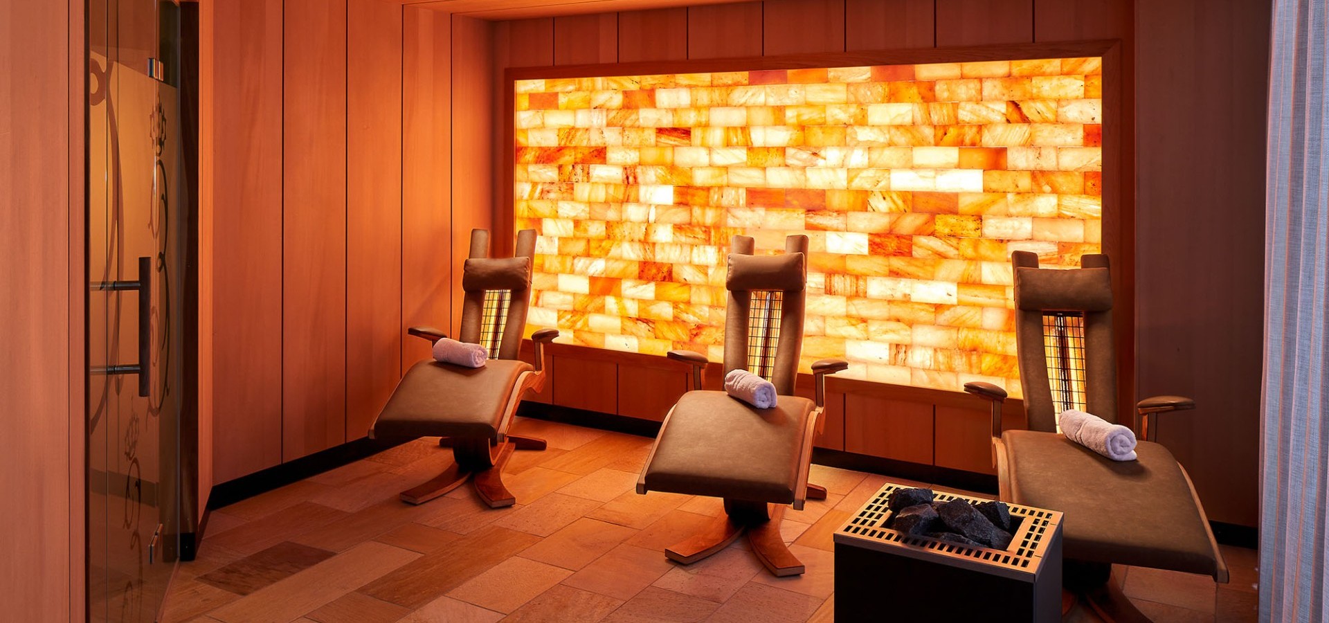 Infrarotsauna mit Liegestühlen und atmosphärischer Beleuchtung.